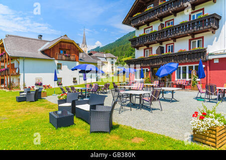 Traditionelle alpine Häuser geschmückt mit Blumen in kleinen Dorf am Ufer des Weißensee, Österreich Stockfoto