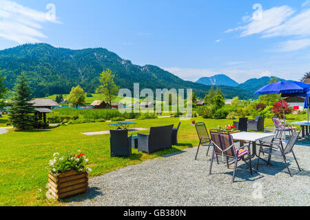 Tische im Garten eines Guest house am Ufer des Weißensee im Sommerlandschaft der Alpen, Österreich Stockfoto