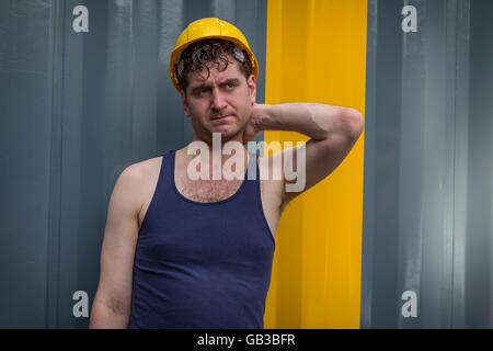 Junge hübsche Bauarbeiter in Tank-Top und gelben Hut Stockfoto