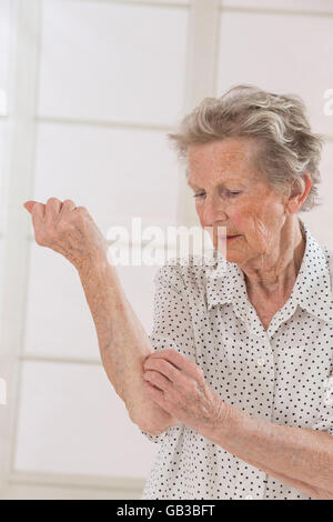Jucken In eine alte Frau Stockfoto