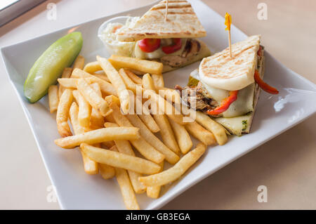 Gegrillten Pesto chicken Panini mit knusprigen Steak frites Cole Slaw und Gurke Stockfoto