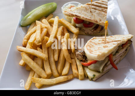 Gegrillten Pesto chicken Panini mit knusprigen Steak frites Cole Slaw und Gurke Stockfoto