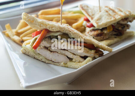 Gegrillten Pesto chicken Panini mit knusprigen Steak frites Cole Slaw und Gurke Stockfoto