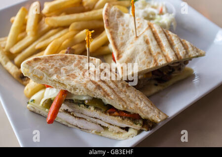 Gegrillten Pesto chicken Panini mit knusprigen Steak frites Cole Slaw und Gurke Stockfoto