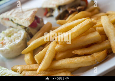 Gegrillten Pesto chicken Panini mit knusprigen Steak frites Cole Slaw und Gurke Stockfoto