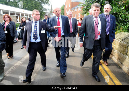 John Healey, Minister für Hochwasserrückgewinnung, Mitte, spricht mit Ken Dunbar, dem Hauptgeschäftsführer des Castle Morpeth Council, links, während eines Spaziergangs durch die überflutete Stadt Morpeth, Northumberland. Stockfoto