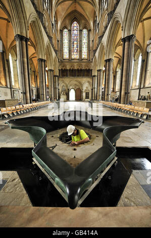 Ein Bauarbeiter installiert das neue Taufbecken aus Bronze, das von William Pye entworfen wurde. Es ist das erste Taufbecken, das seit zwei Jahrhunderten in der Kathedrale von Salisbury installiert wird und am 28. September 2008 vom Erzbischof von Canterbury, Rowan Williams, eingeweiht wird. Stockfoto