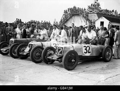 Motorsport - British Empire Trophy - Brooklands. Die drei besten Fahrer und ihre Autos nach dem Rennen, mit Sieger Freddie Dixon (rechts, im Auto 32) feiert mit einem Glas Champagner. Stockfoto