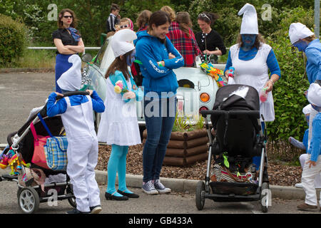 Gruppe von Frauen und Kindern als Schlümpfe verkleidet für ein Karnevalsumzug Stockfoto