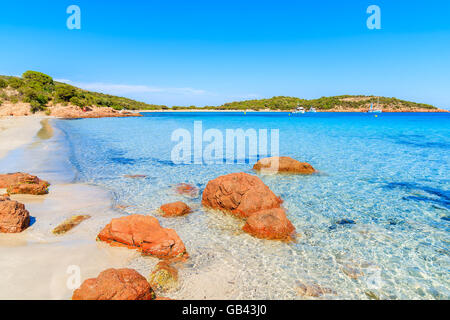 Rote Farbe Felsen am Strand von Santa Giulia mit azurblauen Meerwasser, Korsika, Frankreich Stockfoto