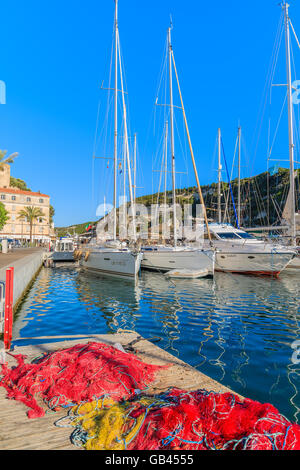 Hafen von BONIFACIO, Korsika - 25. Juni 2015: Fischernetze in Bonifacio Hafen mit Booten, die Verankerung im Hintergrund. Bonifacio ist f Stockfoto