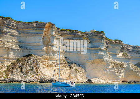 Korsika, Frankreich - 25. Juni 2015: Segelboot auf Kreuzfahrt auf dem Meer in der Nähe von Bonifacio Klippe Kalkfelsen. Bonifacio ist die meisten visite Stockfoto