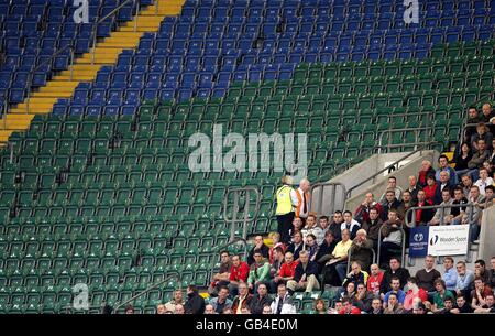 Eine Prise walisischer Fans beobachten die Action von der Steht, während die Sitze leer liegen Stockfoto
