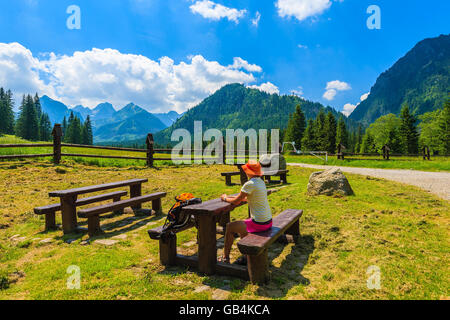 Junge Frau Backpacker sitzen an hölzernen Picknick-Tisch in der hohen Tatra im Sommer, Slowakei Stockfoto