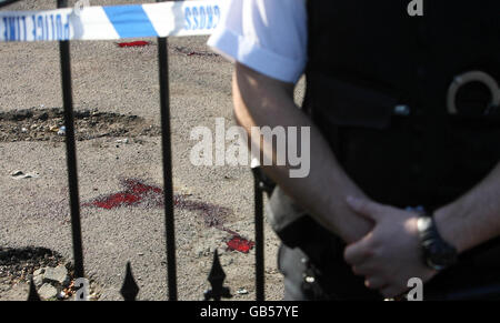 Blut liegt auf dem Boden hinter einem Polizisten in der Coldharbour Lane in Brixton, wo ein Mann erstochen wurde. Stockfoto