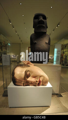 Ron Muecks 'Mask II', ein schlafendes Selbstporträt, sitzt vor einer Statue von der Osterinsel im British Museum, London, die Teil einer neuen Ausstellung namens 'Statuephilia' ist. Stockfoto