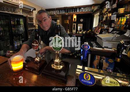 David Morgan, Mitinhaber des Golden Heart Pub in der Nähe von Brimpsfield, Gloucestershire, hinter der Bar seines Pubs, nachdem es zum Good Pub Guide 2009 Pub of the Year ernannt wurde. Stockfoto