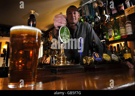 David Morgan, Mitinhaber des Golden Heart Pub in der Nähe von Brimpsfield, Gloucestershire, hinter der Bar seines Pubs, nachdem es zum Good Pub Guide 2009 Pub of the Year ernannt wurde. Stockfoto