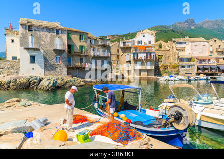 ERBALUNGA, Korsika - 4. Juli 2015: Fischer reparieren Fischernetze in Erbalunga Anschluss am Cap Corse. Dieses kleine Dorf ist kno Stockfoto