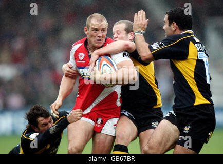 Gloucester Mike Tindall wird von Wespen Tom Voyce, Dave Walder und Jeremy Staunton während des EDF Energy Cup-Spiels im Kingsholm Stadium, Gloucester, angegangen. Stockfoto