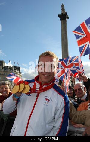 Der dreifache Goldmedaillengewinnerin Chris Hoy zeigt seine Medaillen an Der Festwagen während der Team GB Homecoming Parade in Im Zentrum Von London Stockfoto