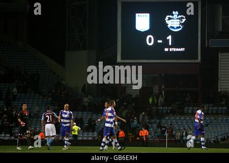 Fußball - Carling Cup - Dritte Runde - Aston Villa gegen Queens Park Rangers - Villa Park. Auf der Anzeigetafel wird die Geschichte angezeigt, während die Spieler beim letzten Pfeifen die Hände schütteln. Stockfoto