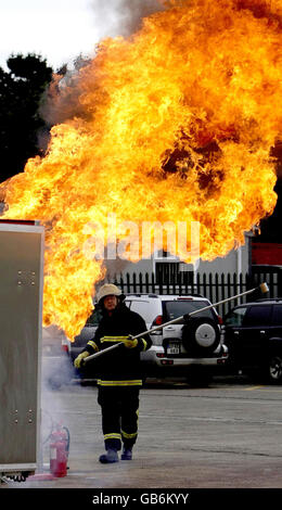 Der Feuerwehrmann Jim O'Brian demonstriert beim Start der Fire Safety Week im Fire Brigade Training Center in Dublin die Gefahren, die das Gießen von Wasser auf einen Splitterbrand mit sich bringt. Stockfoto