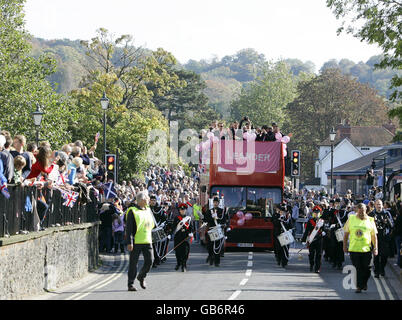 Mitglieder des britischen olympischen Ruderteams winken, während sie in einem offenen Bus fahren, während eine Olympic Rowing Heroes Return Party zu ihren Ehren, Henley-on-Thames, Oxfordshire, stattfand. Stockfoto