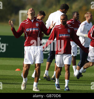 Der englische Rio Ferdinand (links) lacht, als er sich mit Ashley Cole (rechts) während eines Trainings in London Colney, Hertfordshire, aufwärmt. Stockfoto