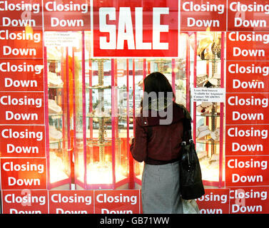 Eine Frau schaut in einem Geschäft in Dublin auf die Schließung des Verkaufs am Tag, an dem Finanzminister Brian Lenihan sein Budget für 2009 ankündigt. Stockfoto