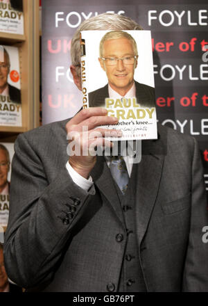 Paul O'Grady hält eine Kopie seines Buches "At My Mother's Knee", in Foyles Buchhandlung, in der Royal Festival Hall, Southbank Centre, London. Stockfoto