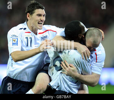 Der englische Wayne Rooney (rechts) feiert sein Tor mit Emile Heskey und Gareth Barry (links) während des FIFA-WM-Qualifikationsspiels im Dinamo-Stadion, Minsk, Weißrussland. Stockfoto