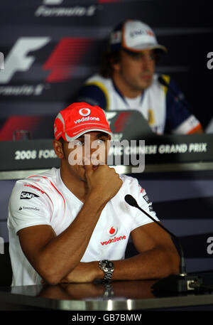 McLaren Mercedes-Pilot Lewis Hamilton sitzt vor Renault Fernando Alonso während der Pressekonferenz vor dem Großen Preis von China auf dem Shanghai International Circuit, China. Stockfoto