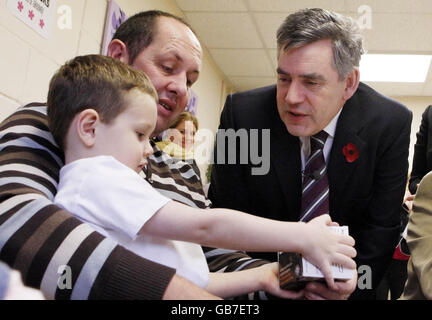 Premierminister Gordon Brown spricht mit Donald Young und seinem Sohn Haydn Young 4 im Cormack's Cafe in Glenrothes während seines ersten Nachwahlbesuchs seit seiner Ernennung zum Premierminister. Stockfoto