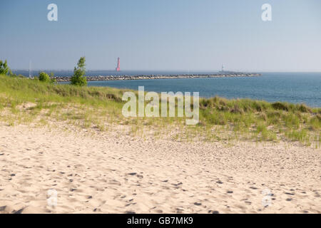 Sanddünen und Dünengras am Ufer des Lake Michigan im Muskegon State Park. Im Hintergrund sind der Leuchtturm und der Kanal Stockfoto