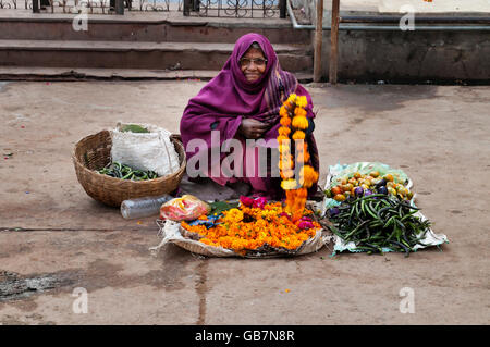 Unbekannte alte arme Frau verkauft Girlanden der Blumen im Tempel. Stockfoto