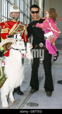 'Chico' mit seiner Tochter Lalla-Khira steht mit Shenkin, der Ziege, dem offiziellen Maskottchen des 3. Bataillons der Royal Welsh, und Goat Major Sgt. David Joseph BEM. Sie sind in Heathrow, als sich ein Jumbo-Jet von British Airways darauf vorbereitet, fast 200 schwer kranke und behinderte Kinder auf einen Traumflug nach Florida zu bringen. Stockfoto