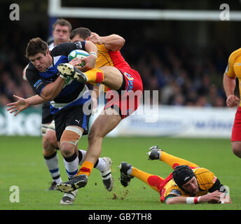 Bath's Michael Lipman bricht an einem Tackle von Newport Gwent Dragons James Arlidge und Luke Charteris (Boden) vorbei während des Heineken Cup Spiels im Erholungsgebiet, Bath. Stockfoto