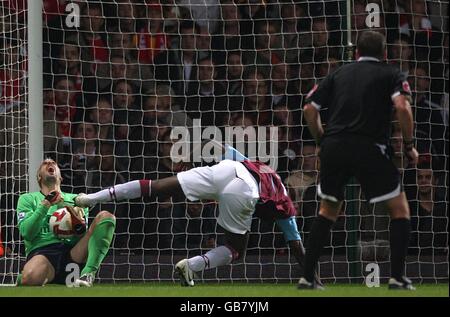 Carlton Cole von West Ham United kollidiert mit Arsenal-Torwart Manuel Almunia als Schiedsrichter Phil Dowd schaut auf Stockfoto