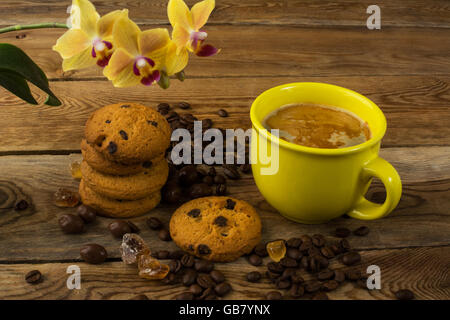 Tasse Kaffee, Kekse und gelbe Orchidee. Tasse Kaffee. Kaffee-Pause. Kaffee am Morgen. Kaffee-Obertasse Stockfoto