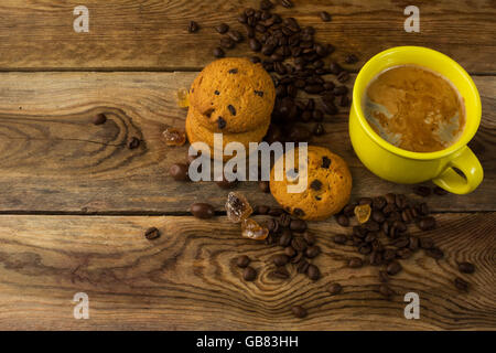 Gelbe Tasse Kaffee und Kaffeebohnen, Ansicht von oben.  Kaffee am Morgen. Kaffee-Obertasse Stockfoto