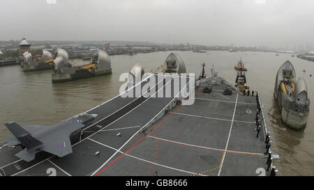 Die Royal Navy Flugzeugträger HMS Illustrious passiert die Thames Barrier, wie es Weg nach London zu Beginn eines neuntägigen Besuch macht. Stockfoto