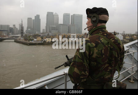 Ein Segler der Royal Navy steht auf dem Deck des Flugzeugträgers HMS Illustrious, als er sich vor Canary Wharf dreht, bevor er in Greenwich festmacht, zu Beginn eines neuntägigen Besuchs in London. Stockfoto