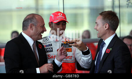 Der britische Formel-1-Weltmeister Lewis Hamilton (Mitte) sieht sich ein Modell eines McClaren F1LM an, das ihm Ron Dennis (links) am McLaren Hauptquartier in Woking gegeben hat. Stockfoto