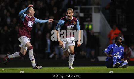 Fred Sears von West Ham United (links) läuft, um seinem Teamkollegen Jack Collison (Mitte) zum Tor zu gratulieren, während Evertons Victor Anichebe ungläubig auf dem Boden sitzt. Stockfoto