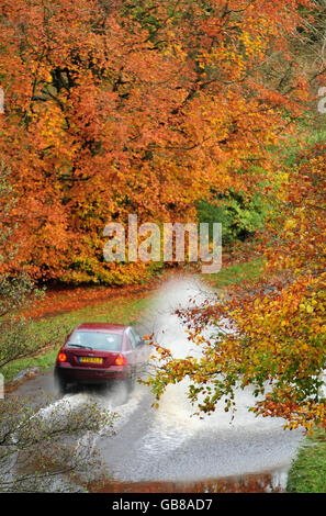 Ein Auto fährt in Brampton bei Carlisle in Cumbria durch das Hochwasser, nachdem in Teilen des Landkreises fast ein Monat Regen an einem Tag einfiel und sintflutartige Regenfälle mehrere Straßen blockierten. Stockfoto