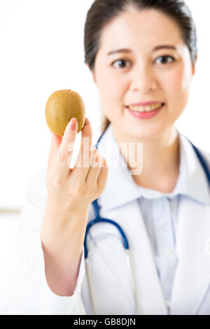 Junge asiatische Ernährungswissenschaftler halten eine Kiwi, gesundes Essen Stockfoto