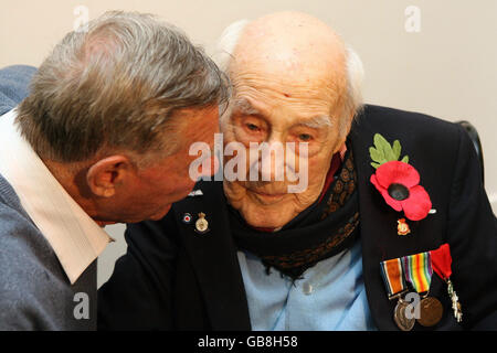 Henry Allingham, 112, der älteste Mann Europas, spricht mit dem Gründer der World war I Veterans Association Dennis Goodwin, neben einem Porträt von Henry, das vom berühmten Kriegsfotografen Don McCullin aufgenommen wurde und in der Tate Britain in London zu sehen ist. Stockfoto