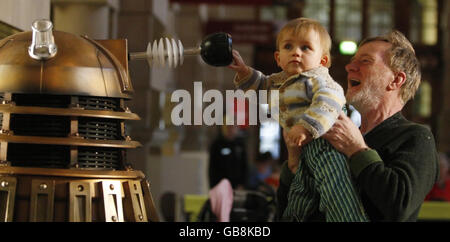 Stevie Reilly und sein Enkel Reuben Drummond werfen einen Blick auf einen Dalek in der Kelvingrove Art Gallery and Museum in Glasgow, vor einer Dr Who-Ausstellung. Stockfoto