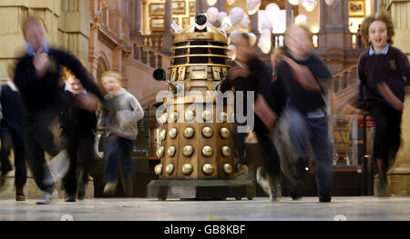 Schulkinder laufen an einem Dalek in der Kelvingrove Art Gallery and Museum in Glasgow vorbei, bevor sie eine Dr WHO-Ausstellung besuchen. Stockfoto